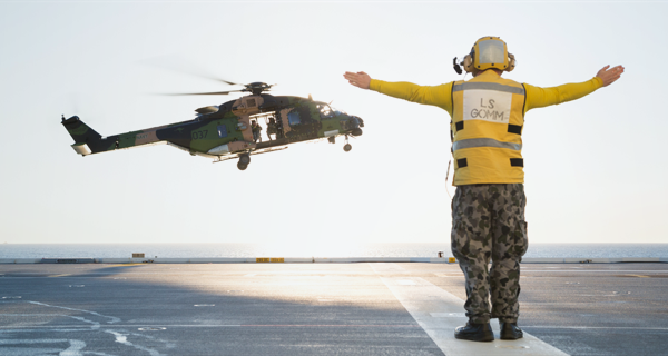 Person with open arms guiding helicopter